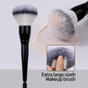 A large, fluffy gray makeup brush is shown with a close-up of its bristles and a hand demonstrating its size.