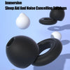A collection of white and black silicone earplugs shown in various forms, including a sphere and a ring shape.