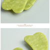 Two light green jade gua sha facial massagers are shown on a white surface.