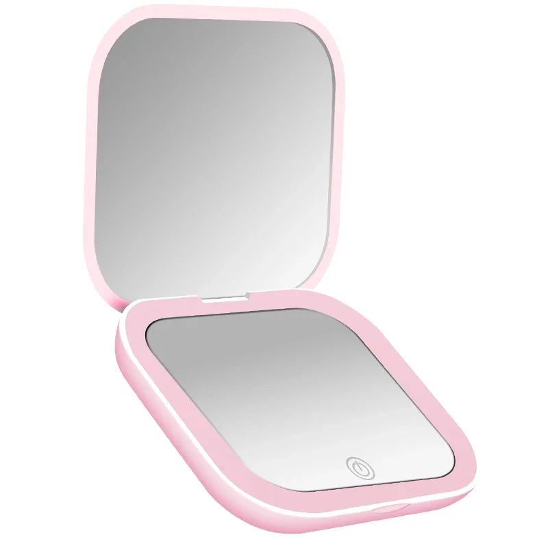 Miroir de vanité pliable rose avec couvercle ouvert et lumière LED intégrée.