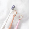 A set of soft bristled toothbrushes in purple and pink colors shown against a white background.