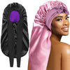 A woman models a pink satin silk hair bonnet cap and a black satin silk hair bonnet cap.
