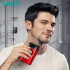 A man holds a red electric foil shaver trimmer against his jawline.