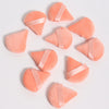 Un set de trois puffs triangulaires roses avec des rubans de satin sur fond blanc.
