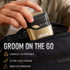 A hand holds a gold and black electric foil shaver for men inside a dark bag, highlighting its compact design.