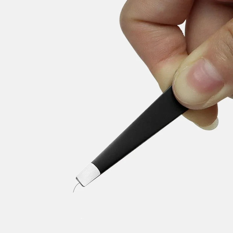 A hand is holding a black precision stainless steel eyebrow tweezers with a silver tip.