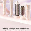 A collection of professional automatic rotating ceramic hair curlers in white and pink tones displayed on a light surface.