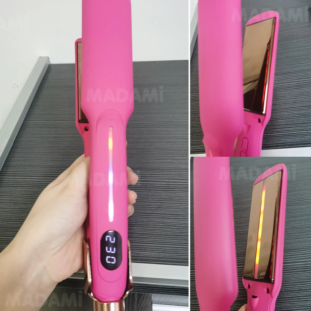 A hand holds a pink professional infrared hair straightener and curler device.