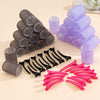 A set of self-grip hair rollers in various shades of gray, purple, and pink are displayed on a light background.