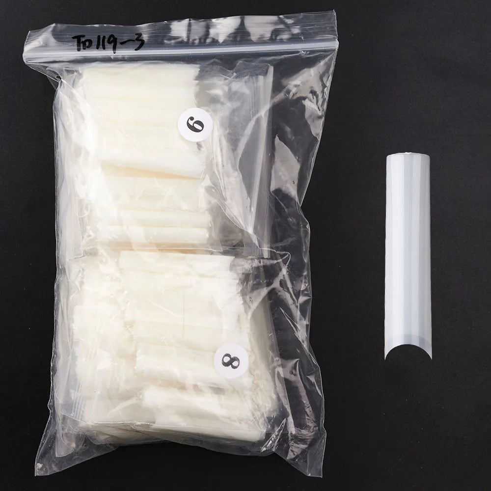 A clear plastic bag containing a set of 504 acrylic false press-on nails, including six and eight nails, next to a single nai