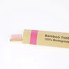 A package of bamboo toothbrushes with pink bristles and a label indicating 100% biodegradable.