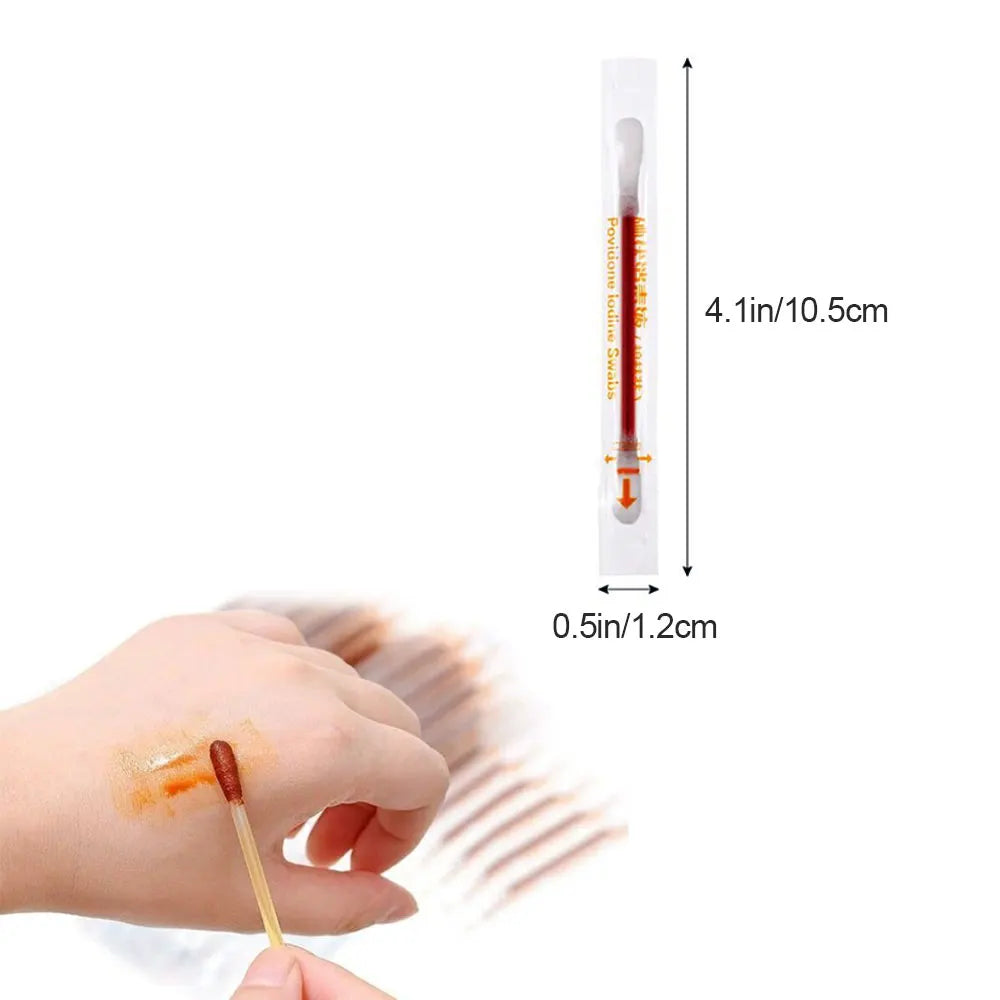 A hand is holding a disposable medical iodine cotton swab for disinfection.