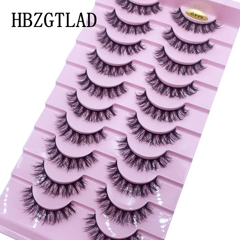 Plateau en plastique rose contenant plusieurs rangées de faux cils de renard noirs pour application.