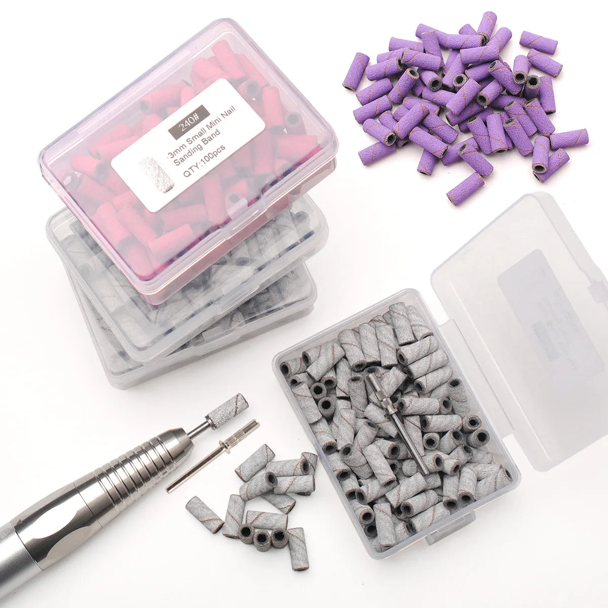 A collection of pink and purple mini sanding bands and nail drills packaged in clear plastic containers.