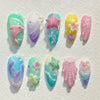 A set of 8 press-on nails featuring gradient blue and pink colors with starfish and floral designs.