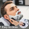 A man is using a silicone bath and body scrub brush to create foam on his face.