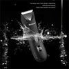 A black Kemel body water wash design hair trimmer is shown with water splashing around it.