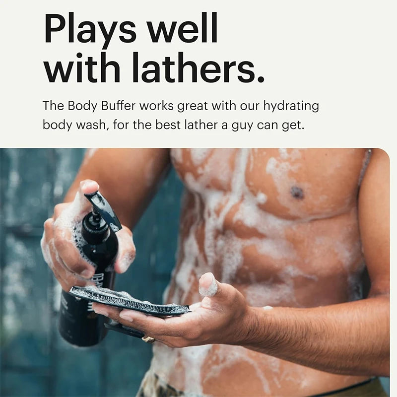 A person is using a black bottle of Body Buffer wash and a soft silicone scrubber on their chest while bathing.