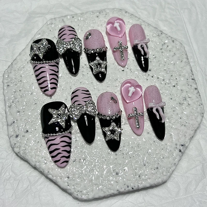 A set of glitter diamond press on nails featuring black, pink, and zebra print designs displayed on a white surface.