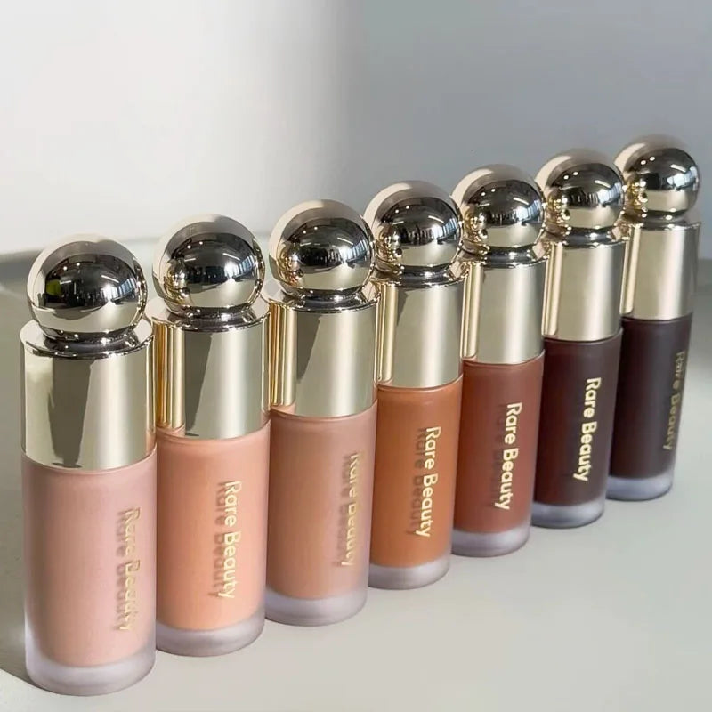 A row of liquid bronzer contour foundation sticks in various shades lined up on a white surface.