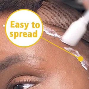 Gros plan d'une personne appliquant de la colle pour perruque invisible sur sa peau pour une adhérence parfaite des cheveux.