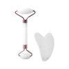 A rose gold gua sha tool with a white stone is shown against a white background.