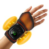 A hand is holding a black pneumatic massager device with yellow silicone pads on the fingers.
