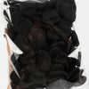 A hand holds a clear plastic bag filled with black latex-free finger puffs for makeup application.