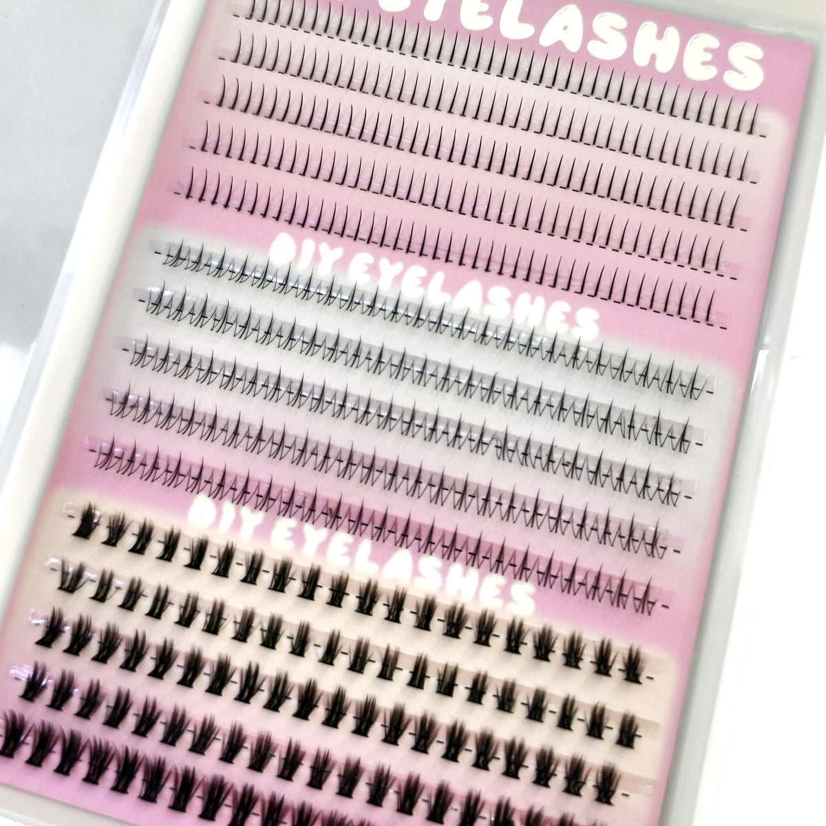 A display of fifteen rows of DIY wispy extension eyelashes on a clear plastic card.