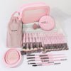 A pink professional makeup brush kit with various tools and a sponge is displayed on a white box.