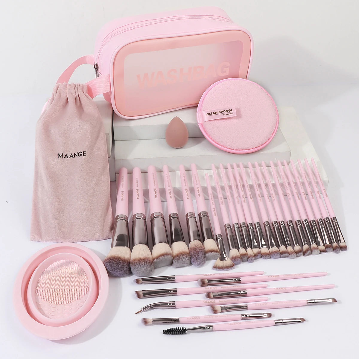 A pink professional makeup brush kit with various tools and a sponge is displayed on a white box.