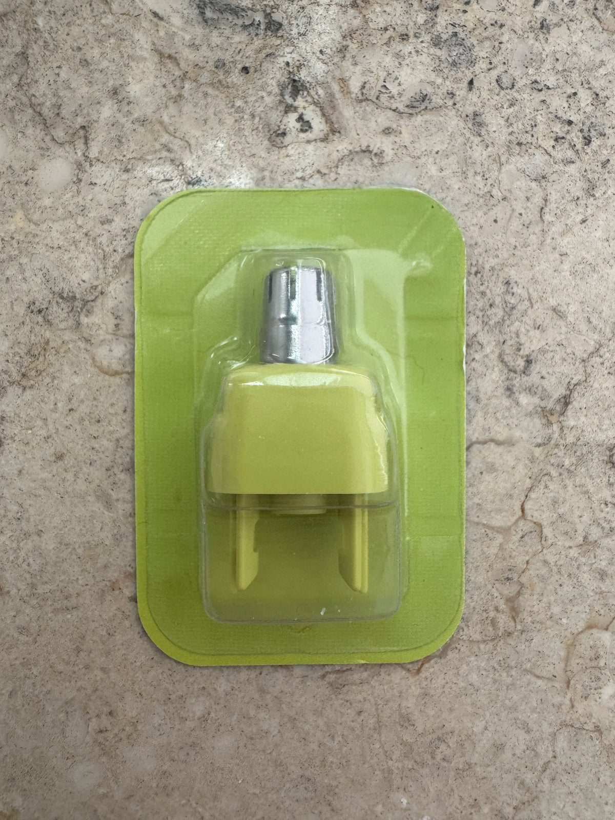 A precision electric beard trimmer in a light green plastic case resting on a speckled countertop.