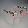 Par de gafas de lectura cuadradas con montura de estampado de leopardo y temples rosas sobre fondo gris.