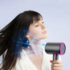 A woman is using a black hair dryer with negative ion technology to style her long dark hair.