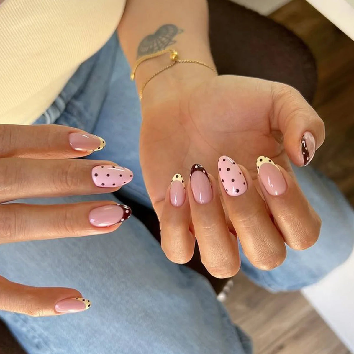 A hand displaying various red and pink striped press-on nails on fingers.