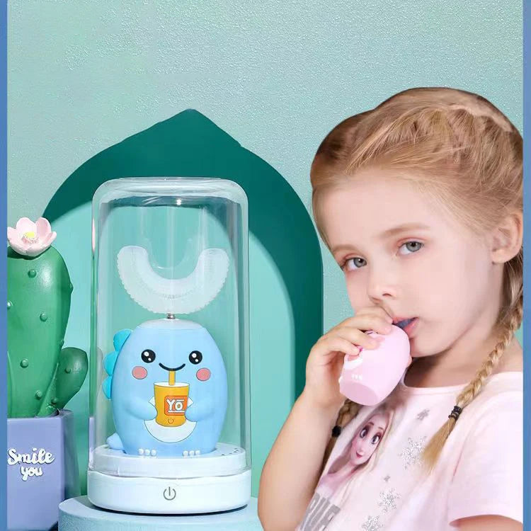 A young girl is using a blue electric toothbrush shaped like a smiling face in a clear holder.