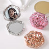 A vintage rose design double-sided pocket makeup mirror with a pink rose and gold accents.