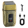A gold-colored electric shaver with a textured body and a black charging cable and a shaving brush.