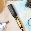 A black hair straightener with a gold accent is shown next to a map and a straw hat, suggesting travel.