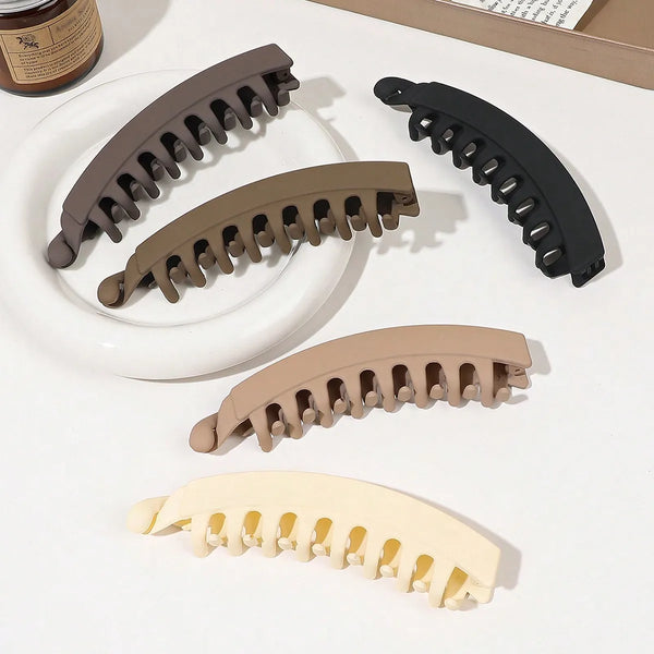 A set of five banana-shaped hair clips in various shades of brown and black for strong grip styling.