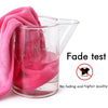 A pink towel is submerged in a clear glass measuring cup, demonstrating a fade test for pillow covers.