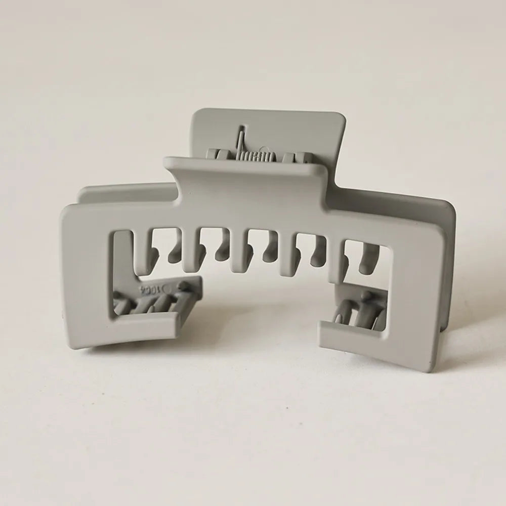 A matte gray non-slip hat claw clip with multiple gripping teeth for securing baseball caps.