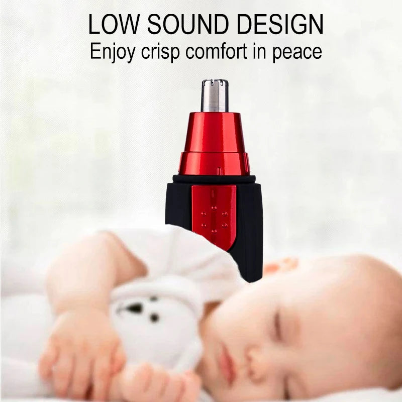 A red and black battery grooming trimmer is shown above a sleeping baby.