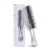 A clear plastic Japanese-style scalp massage brush comb for hair styling and relaxation is shown next to its packaging box.