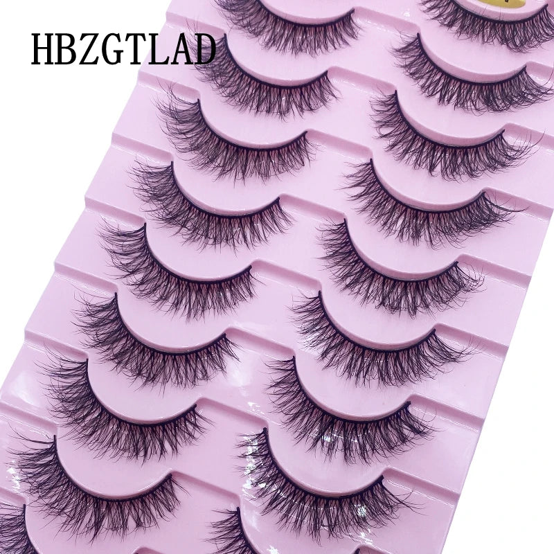 Un plateau en plastique rose contenant plusieurs rangées de faux cils de renard noirs.