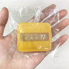 A yellow air cushion makeup puff set in a clear plastic storage bag is held in a hand.