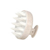 Brosse pour cuir chevelu en silicone beige avec plusieurs poils pointus.