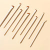 A set of precision angled eyeliner and eyebrow makeup brushes displayed diagonally on a light beige background.
