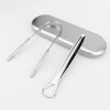 Stainless steel U-shaped tongue scraper resting on a silver rectangular surface.