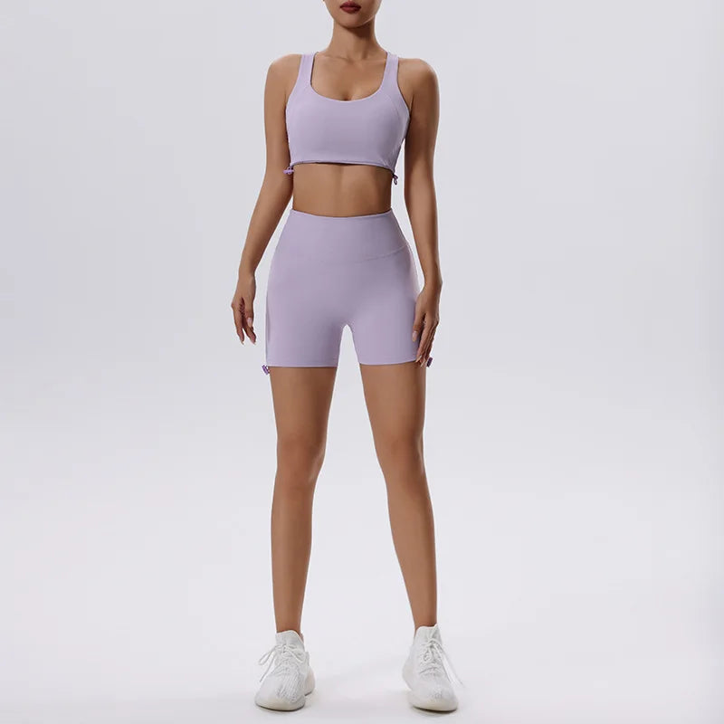 Una mujer modela un conjunto de yoga y gimnasio lavable y de secado rápido en color lavanda, compuesto por un top corto y pan